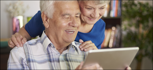 Älteres Ehepaar lächelt beim Spielen mit einem Tablet