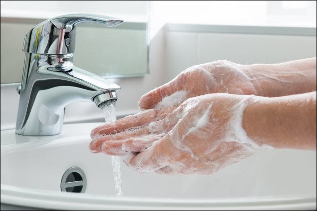 Händewaschen mit Seife unter einem Wasserhahn.