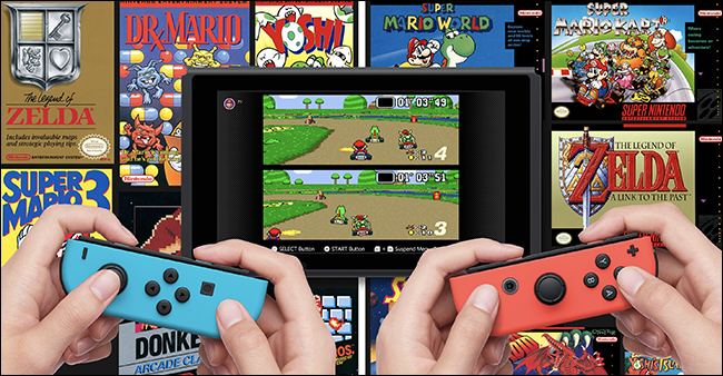 Zwei Hände, die Nintendo Switches beim Spielen halten "Mario Kart" mit anderen Nintendo NES-Spielen hinter dem Bildschirm.